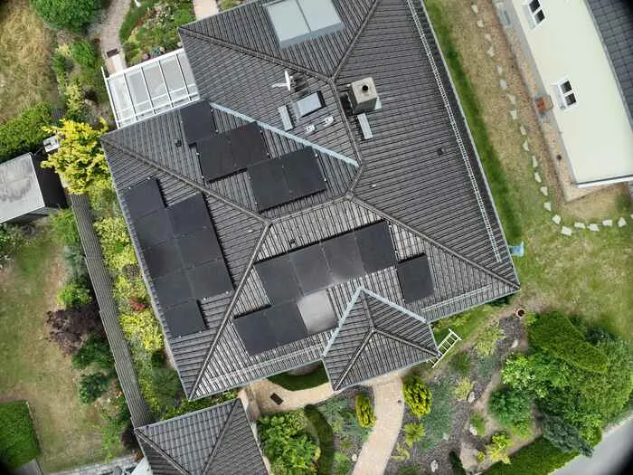 Luftaufnahme eines Hauses mit Solarmodulen auf drei Seiten eines dunklen Ziegeldachs in Weinböhla